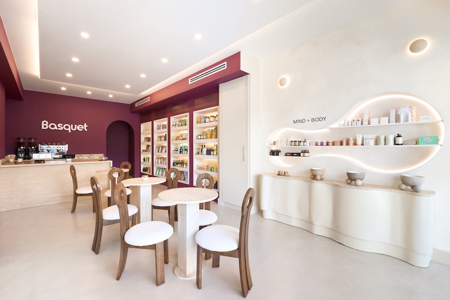 Basquet wellness-centric online grocery brand miami store burgundy paint grocery aisle shelving sculptural wall niche travertine tables wood chairs