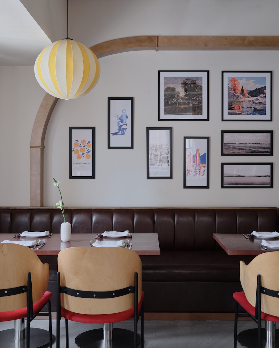 Capito Café Bishkek Kyrgyzstan industrial loft raw concrete walls exposed pipes wall art pink chairs yellow white lantern lights staircase indoor plants wall art