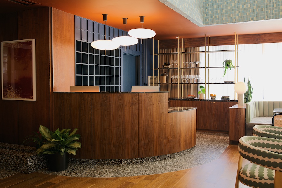 Municipal Grand midnight auteur savannah georgia midcentury design reception wood desk lobby blue key shelf