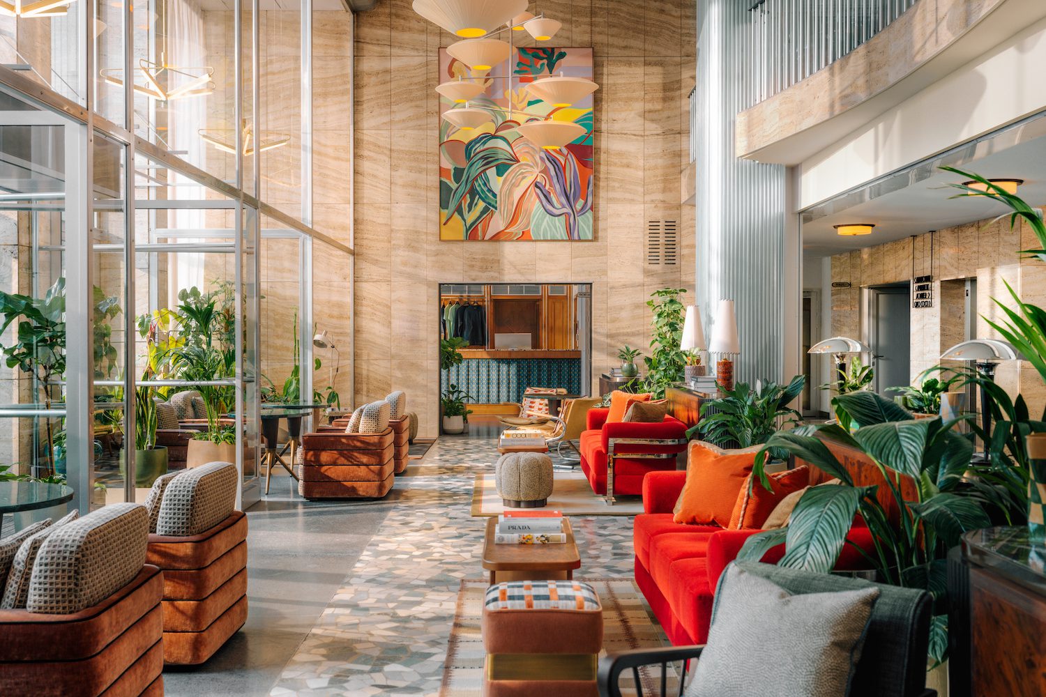 the hoxton vienna double height lobby midcentury bright orange armchairs area rugs artwork