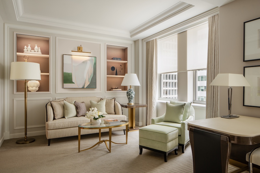 waldorf astoria new york park avenue junior suite bed living room light green armchair table lamps wall niche shelving